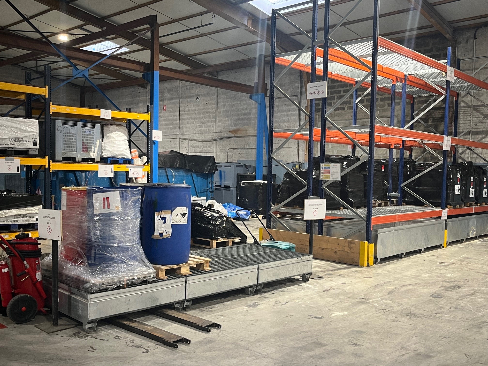 Déchets dangereux rangés sur des racks dans un centre de stockage – Organisation et traçabilité des déchets avec BDS